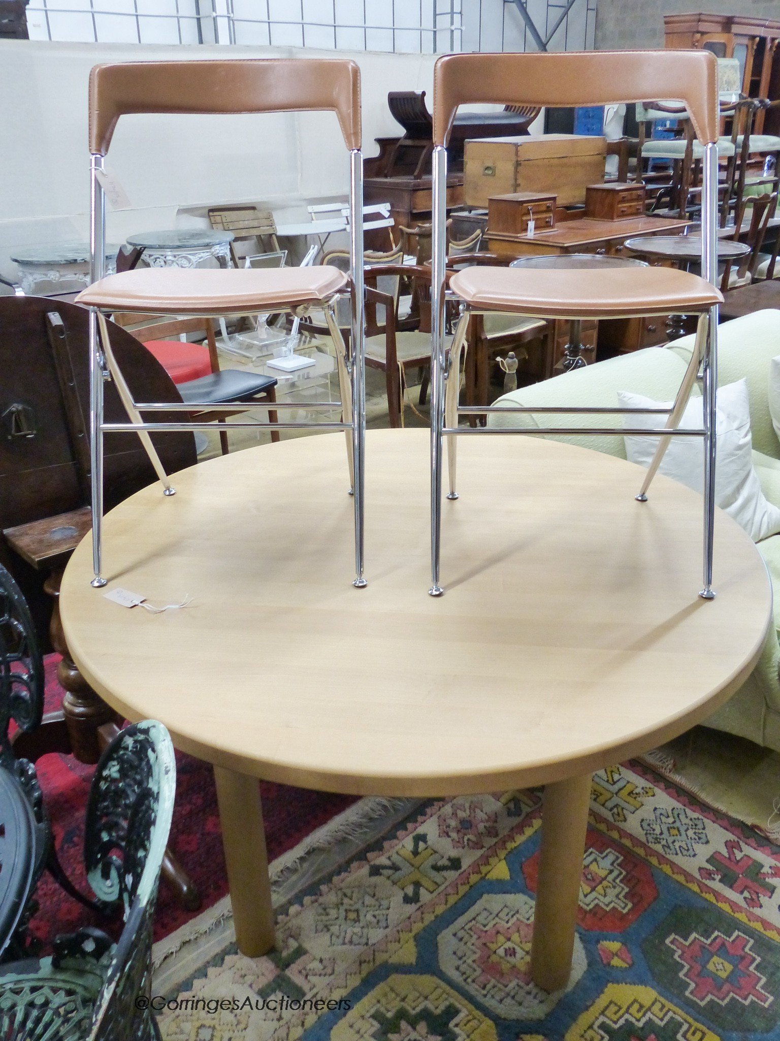 A circular beech breakfast table, depth 122cm, and two Italian chrome chairs.